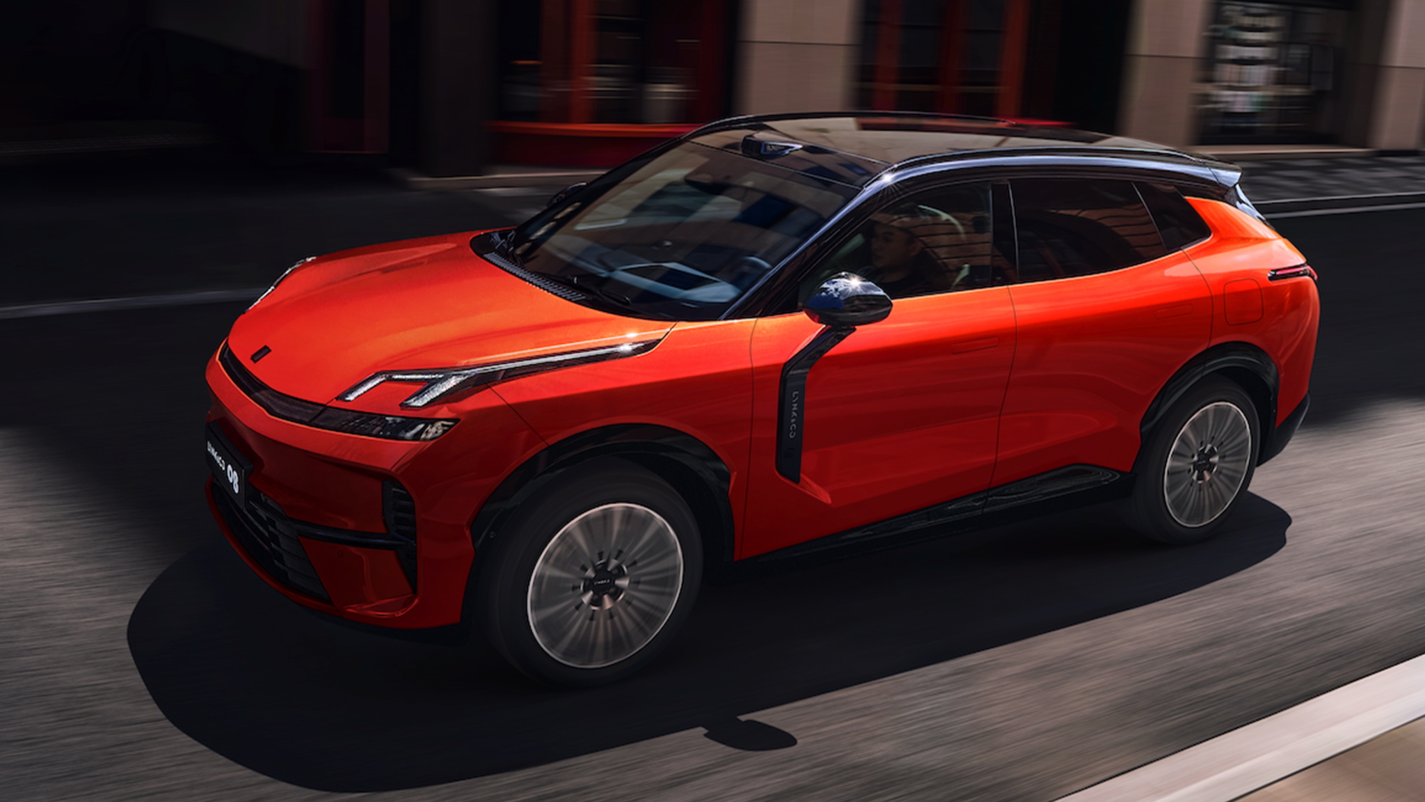 Parlak turuncu renkli modern bir plug-in hibrit SUV, şehir ortamında park halinde