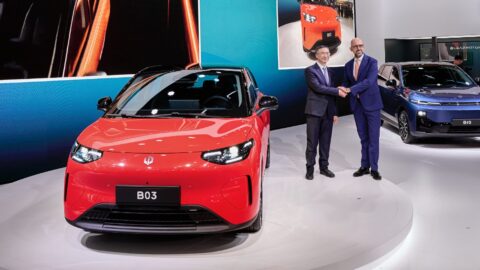 Bir elektrikli otomobilin fabrika üretim hattındaki görüntüsü, robotik kollar ve endüstriyel aydınlatma