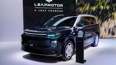 Bir elektrikli otomobilin fabrika üretim hattındaki görüntüsü, robotik kollar ve endüstriyel aydınlatma