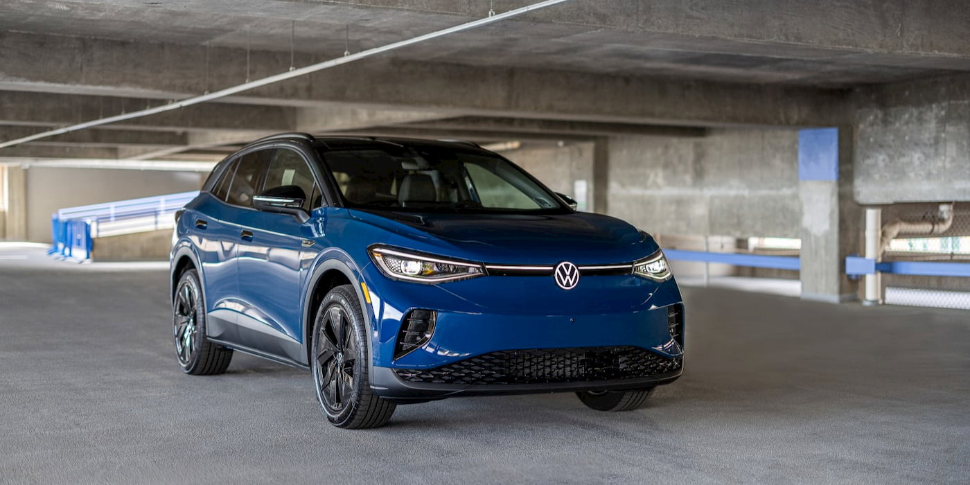 Volkswagen ID.4 elektrikli SUV bir şarj istasyonunda park halinde, arka planda bulutlu gökyüzü