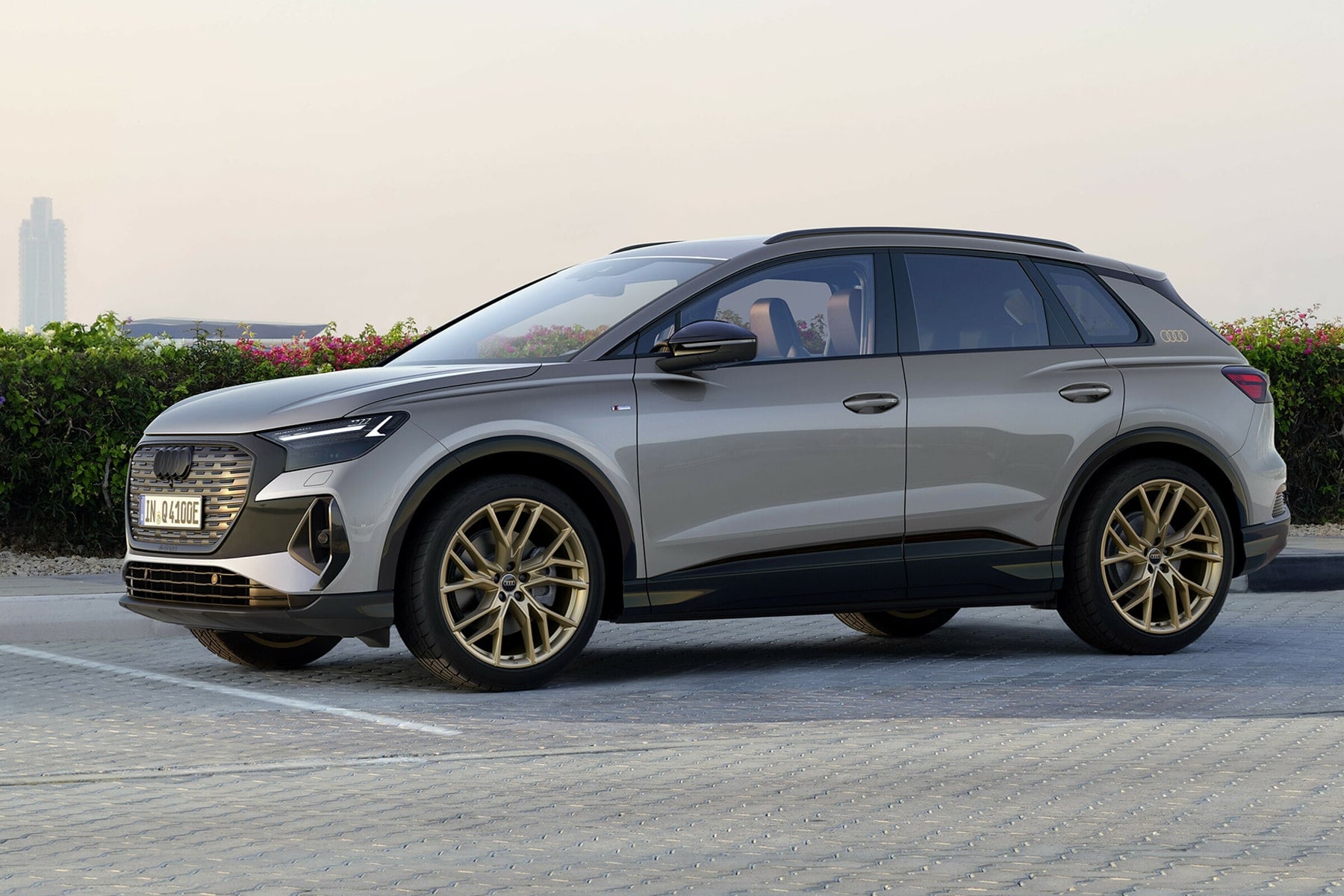 Bir Audi Q4 e-tron aracının şarj portuna kablo bağlanmış halde sokakta park edilmiş görüntüsü
