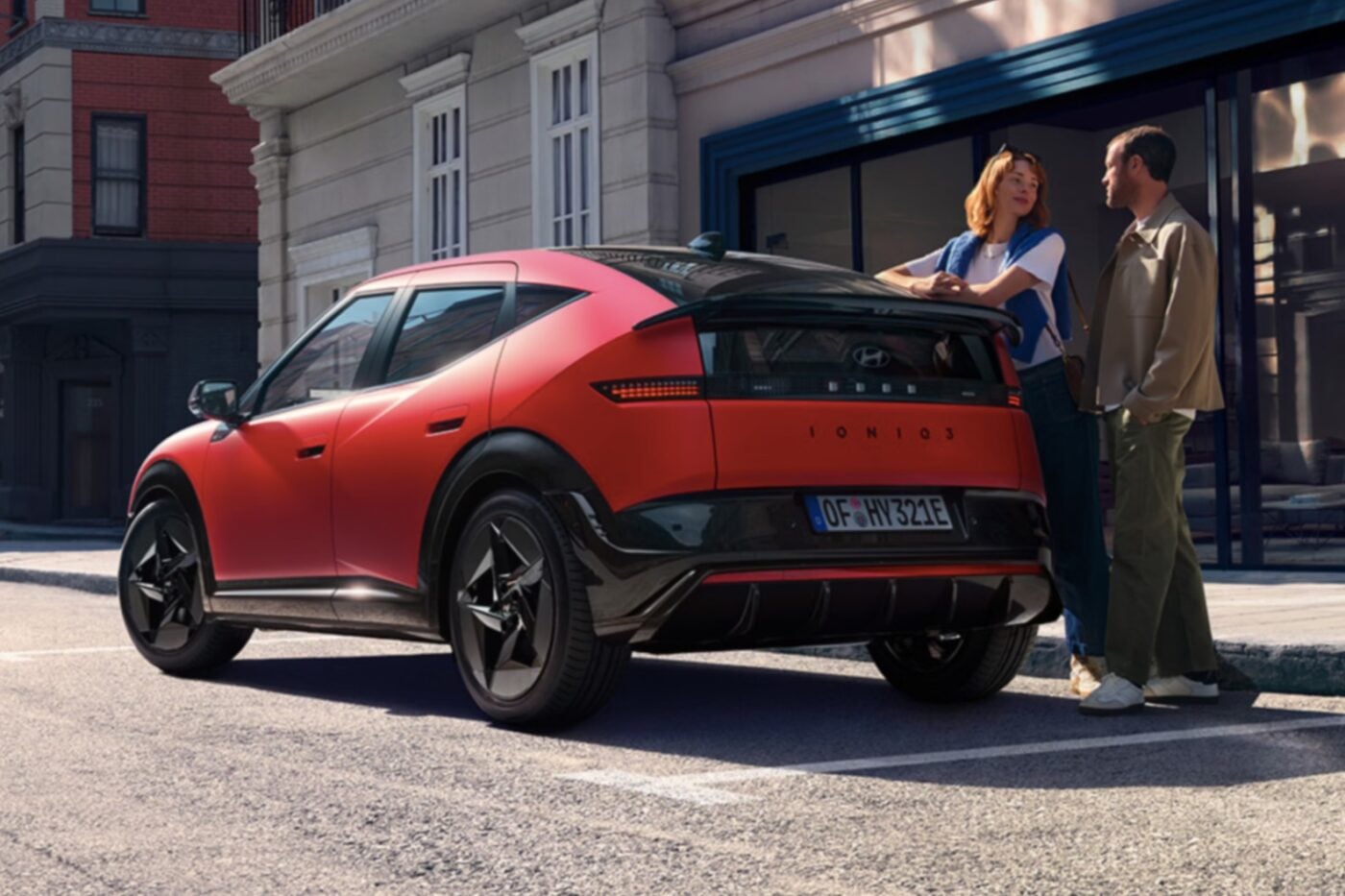 Hyundai Ioniq 3 elektrikli otomobilin kompakt SUV profili, şehir içi bir yolda ilerlerken görülüyor.