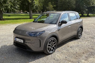 Hyundai Ioniq 3 elektrikli otomobilin kompakt SUV profili, şehir içi bir yolda ilerlerken görülüyor.