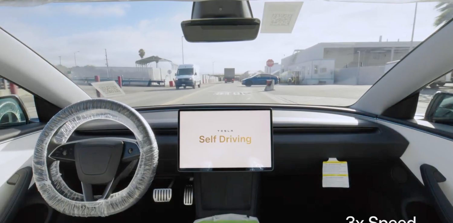 Avrupa'da bir otoyolda seyir halindeki bir Tesla otomobilin sürücü koltuğundan görünümü, direksiyon ve ön camda yol manzarası