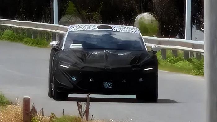 Kamuflajlı uzun dingil mesafeli elektrikli sedan test aracı yolda sürüş halinde
