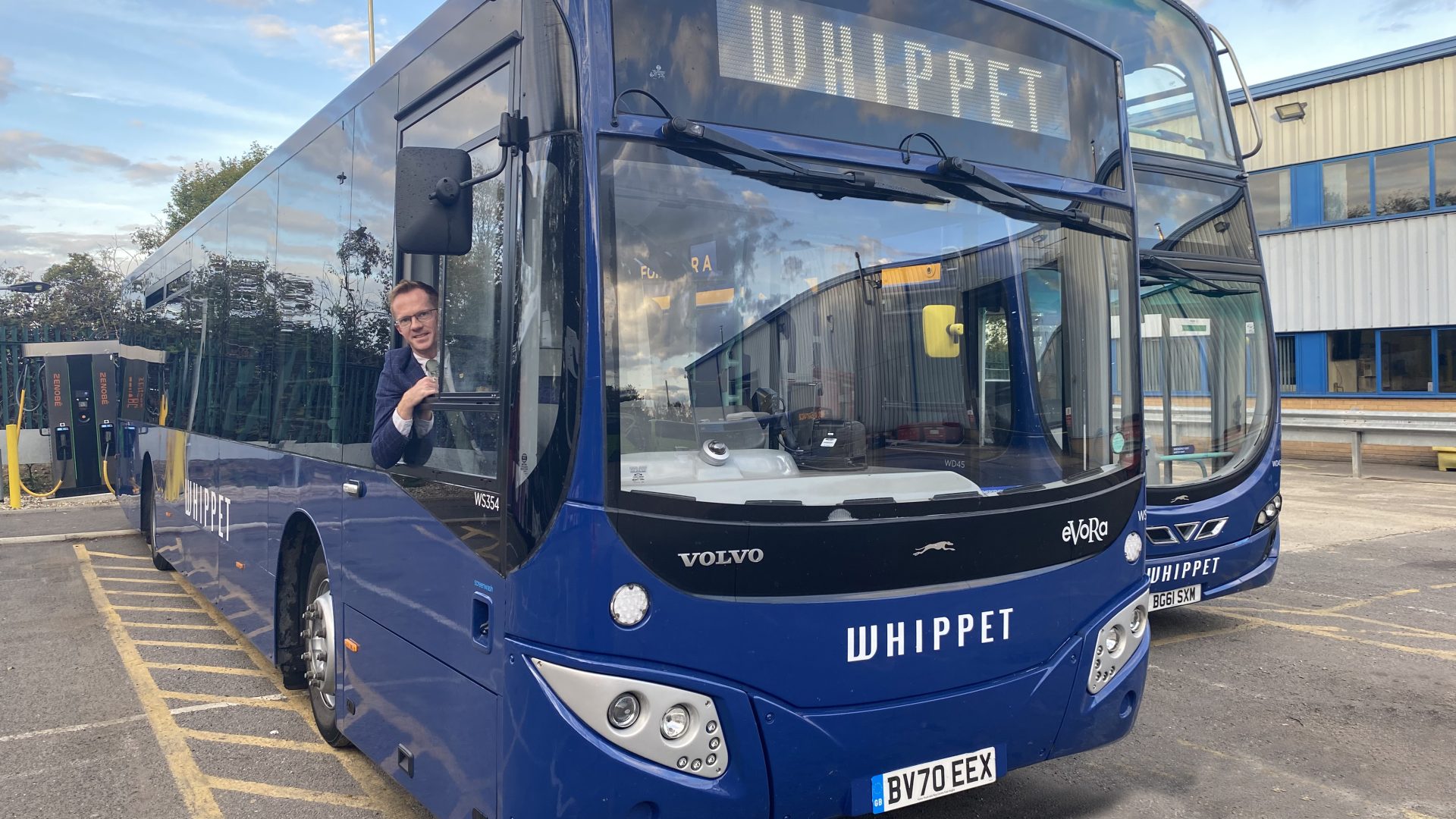 Cambridgeshire'da modern bir elektrikli otobüs, sıfır emisyonlu filo yenileme kapsamında şehir caddesinde park halinde.