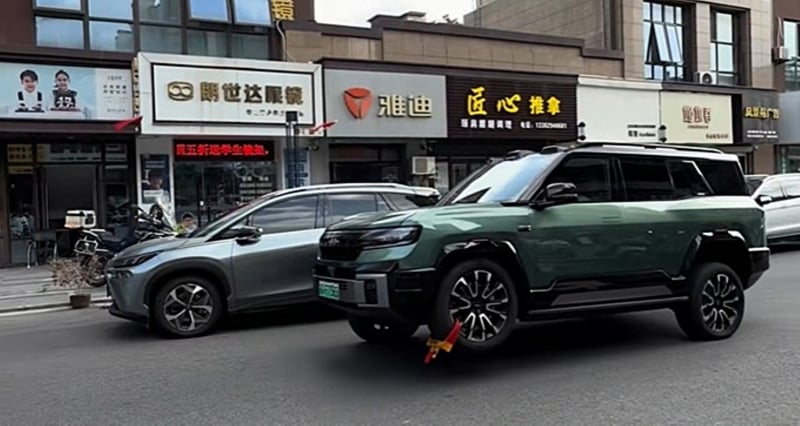 BYD Bao 8 aracının üç tekerlek üzerinde hareket ettiği bir cadde görüntüsü