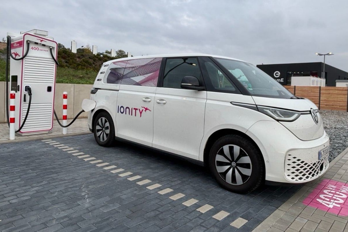 Ionity'nin batarya depolama sistemine sahip modern hızlı şarj parkı, akşam ışıklarında elektrikli araç şarj sahnesi