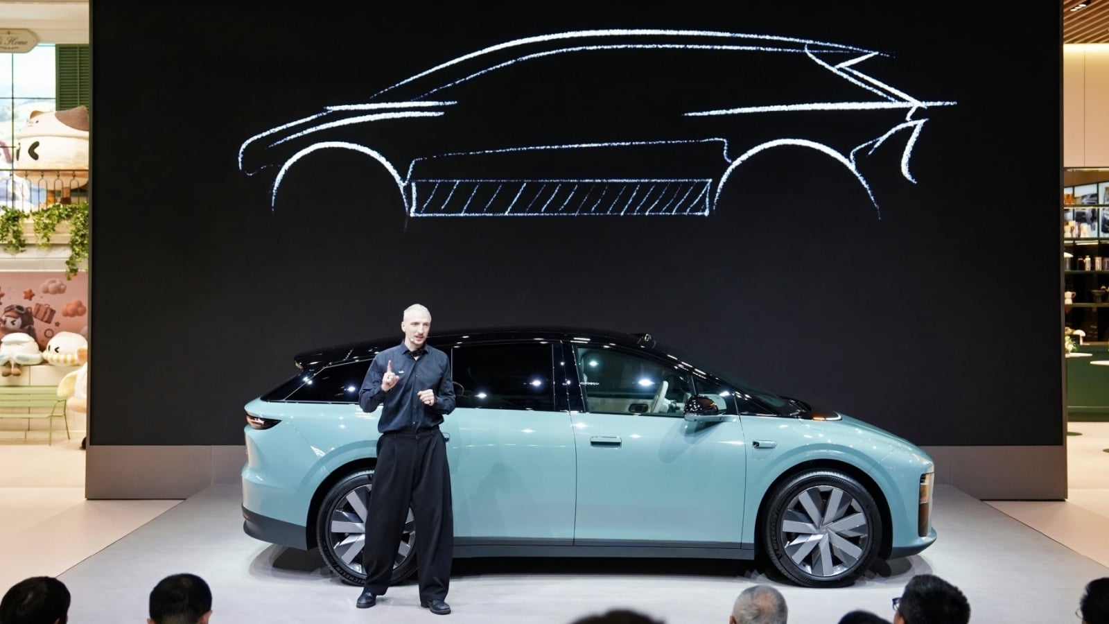 Paris Otomobil Fuarı'nda sergilenen Li Auto i6 crossover modeli, kalabalık bir fuar alanında ön ve yan profilden görülüyor.