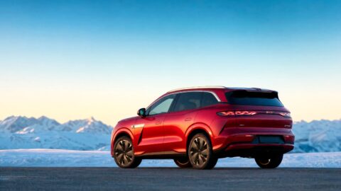 Paris Otomobil Fuarı'nda sergilenen büyük bir elektrikli SUV, fuar ışıkları altında şık bir görünüm sergiliyor.