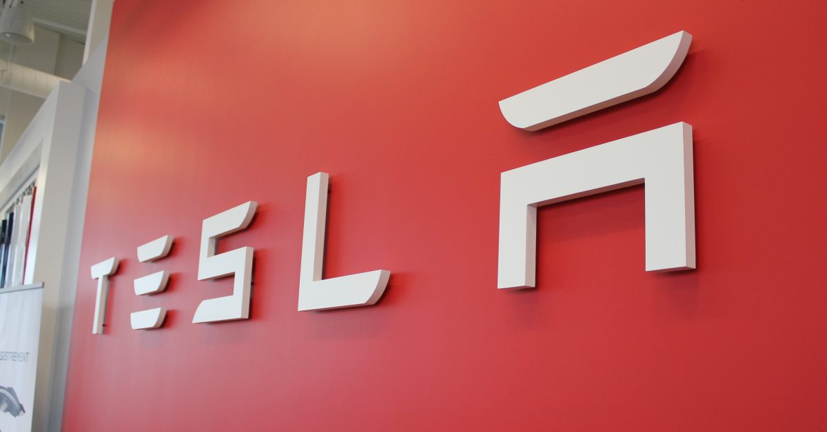 Tesla fabrikasında Model 3 ve Model Y üretim hattı, robotik kollar ve işçiler