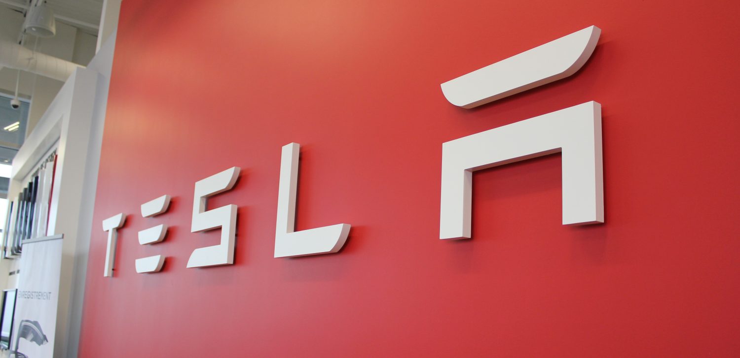 Tesla fabrikasında Model 3 ve Model Y üretim hattı, robotik kollar ve işçiler