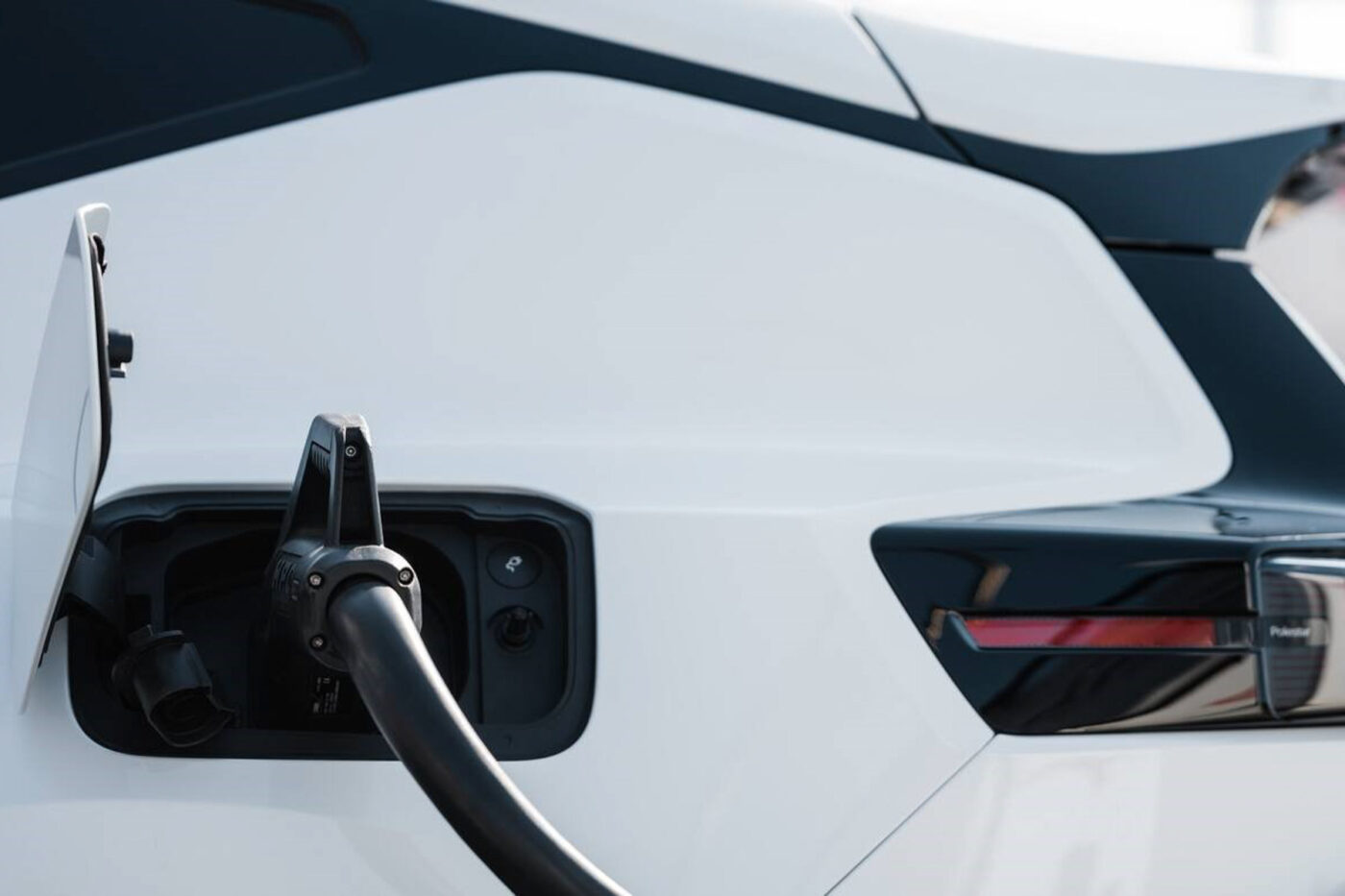 Akdeniz manzaralı bir noktada elektrikli araç şarj istasyonu ve park halindeki bir elektrikli otomobil