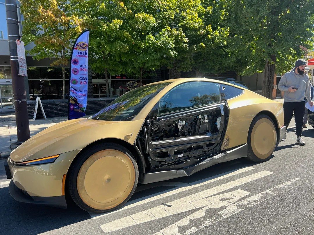 Philadelphia'da bir sokakta kapı paneli eksik Tesla Cybercab.
