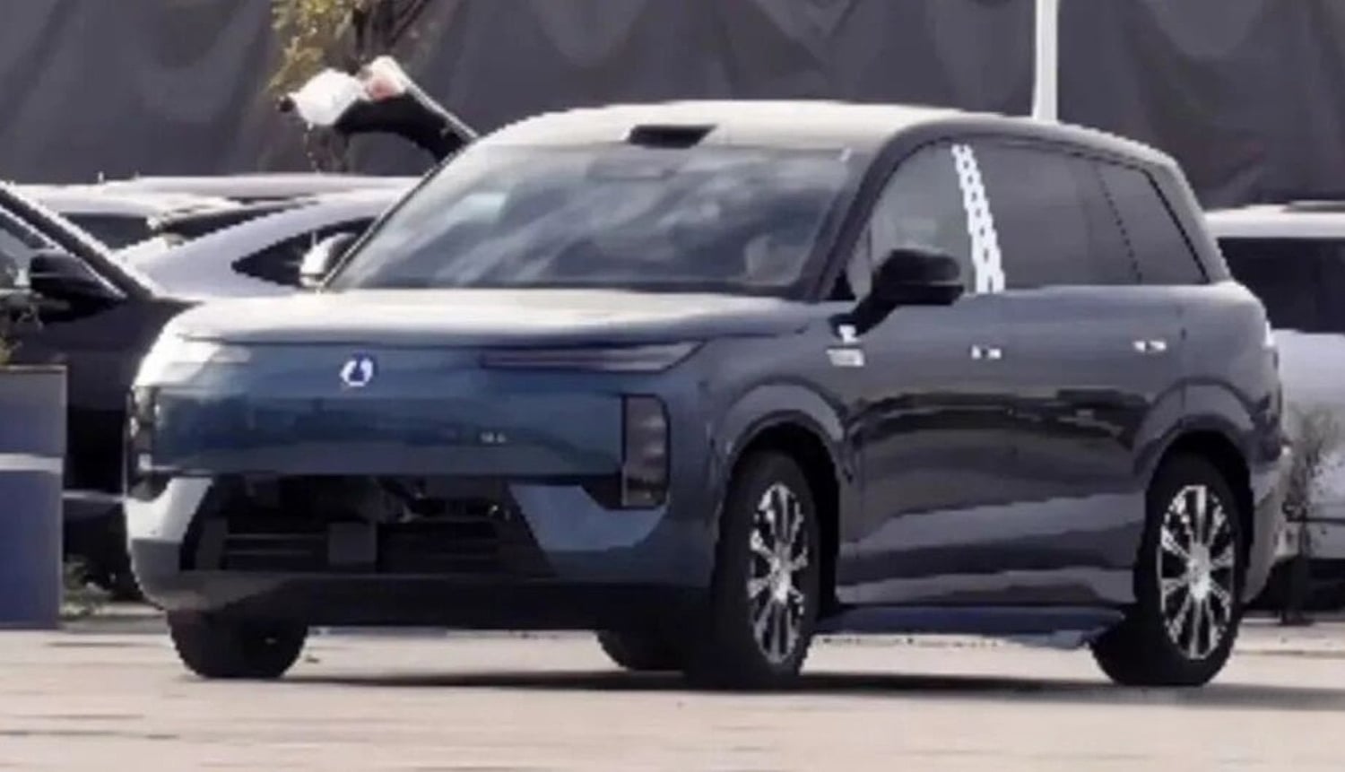 Kamuflajsız BYD Denza N8 EV, büyük SUV, şehir caddesinde park halinde.