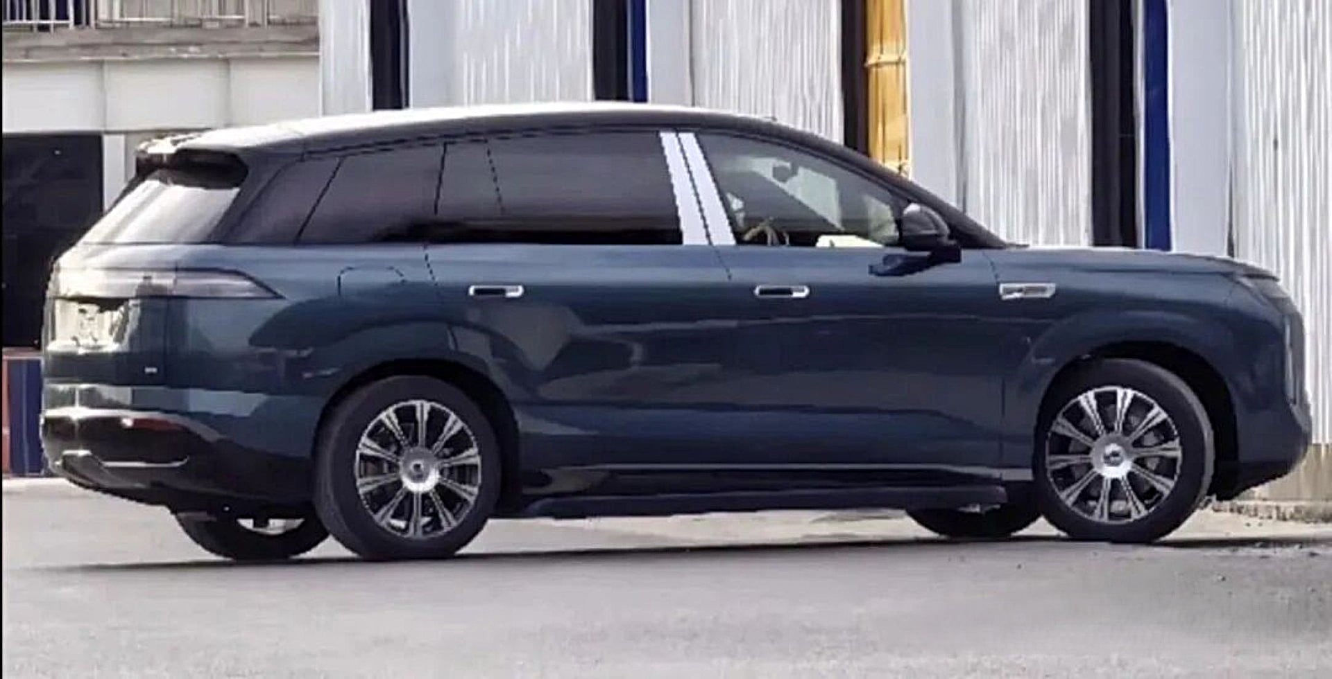 Kamuflajsız BYD Denza N8 EV, büyük SUV, şehir caddesinde park halinde.