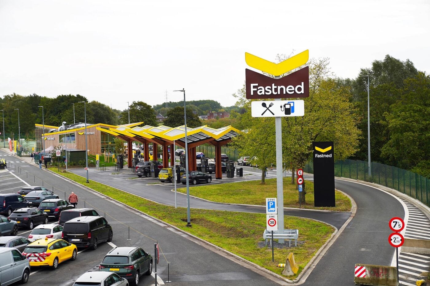 Fastned hızlı şarj istasyonunda bir elektrikli otomobil şarj oluyor, modern tasarım, gün ışığı