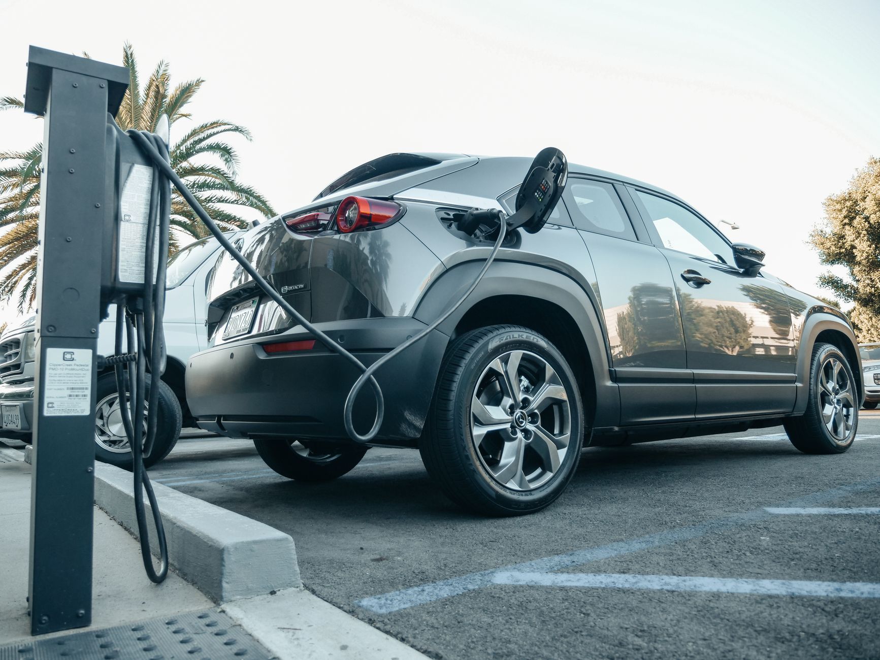 Afrika haritası önünde elektrikli araç şarj istasyonları ile el sıkışan iki profesyonel