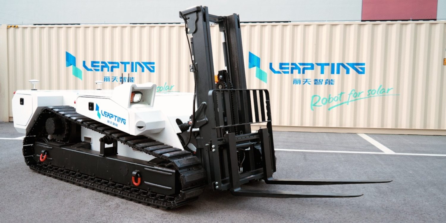 Çölde güneş panelleri arasında çalışan paletli otonom elektrikli forklift robotu