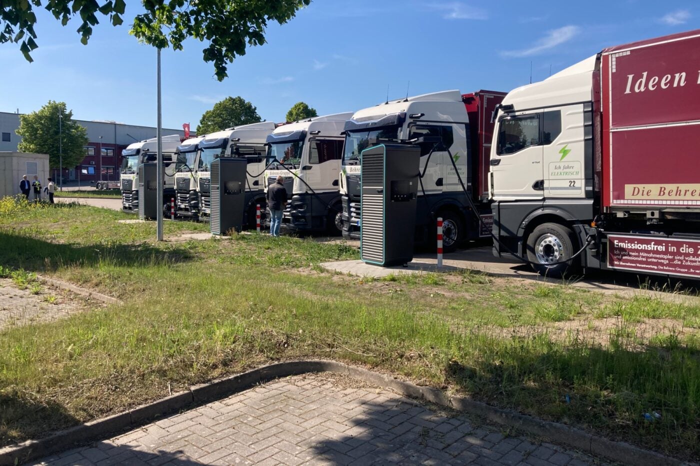 Sanayi bölgesinde paylaşımlı şarj istasyonlarında park halindeki elektrikli kamyonlar